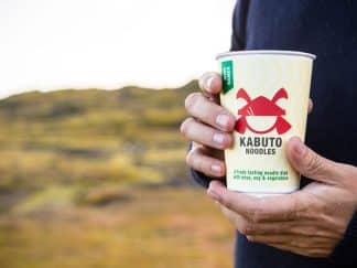 Kabuto Noodles product in the hands of a man in a field